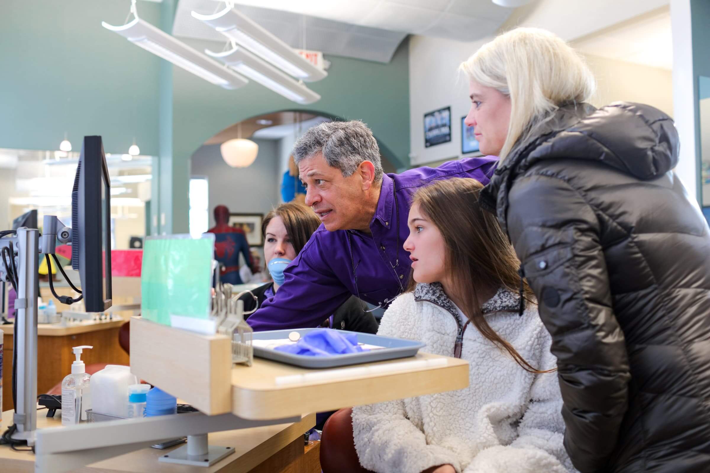 Doctor and patient and parent looking at screen